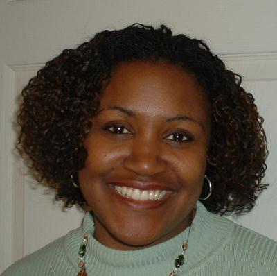 A smiling client wearing a softly curled natural style